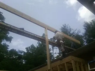 Carpenter setting a ridge beam over a new addition frame — Ice Dam Removal by Roofing Brothers in Ewell
