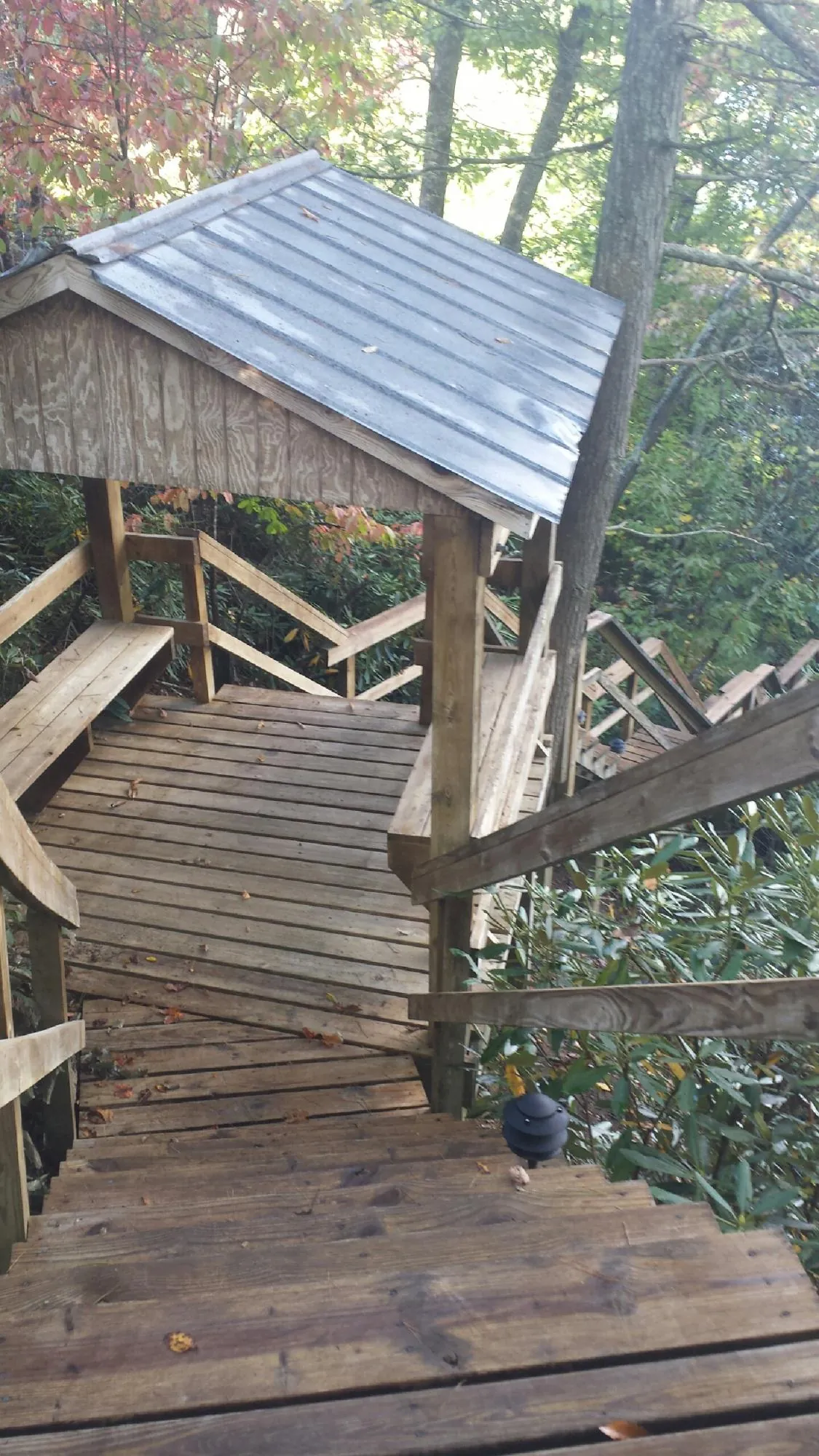 Metal roofed shelter over wooden steps on a wooded walkway — Skylight Repair & Installation work by our crew in Ewell