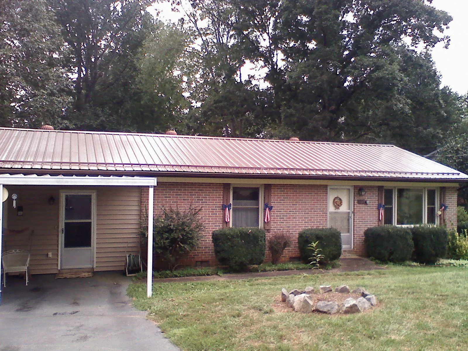 Bronze metal roof and carport on a brick ranch home — Roof Repair work by our crew in Ewell